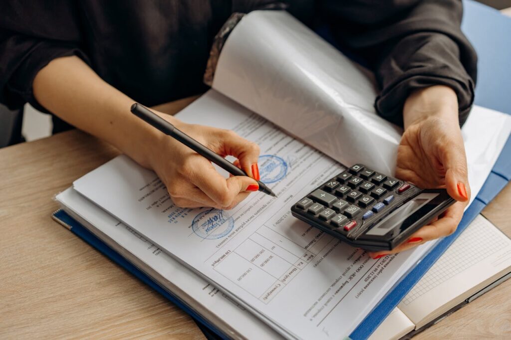 "Professional using calculator for tax preparation and accounting work"